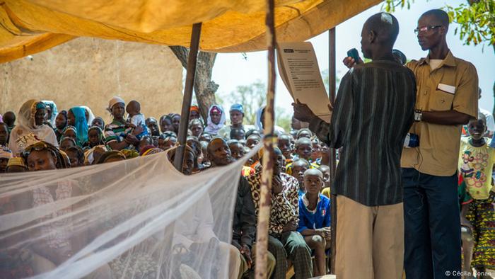 Ein Gesundheitsarbeiter erzählt bei einer Gemeindeversammlung in Burkina Faso, wie man Malariainfektionen vorbeugen kann (Foto: Cécilia Conan)