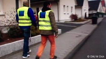 Zwei Männer der Bürgerwehr Radevormwald gehen Straße entlang - (Foto: Wolfgang Dick/DW)
