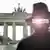 Asocijacija na špijuna - Kontura čovjeka sa šeširom ispred Brandenburške kapije u Berlinu.