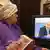 Женщина смотрит выступление Путина по телевидению