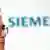 Джо Кезер и логотип фирмы "Сименс"