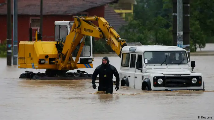 Serbian police officer walks in flood waters near Belgrade.
