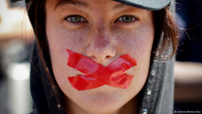 Une femme proteste contre l'adoption de nouvelles lois sur les secrets d'État avec du ruban adhésif sur la bouche