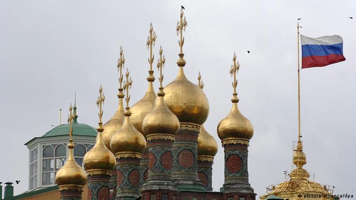 Церковные купола рядом с флагом России