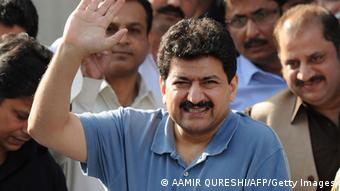 Leading Pakistani TV journalist Hamid Mir, (C), who survived an April attack by gumen in Karachi, waves as he leaves the Supreme Court in a wheelchair after his appearance before the judicial commission in Islamabad on May 19, 2014 (Photo: AAMIR QURESHI/AFP/Getty Images)