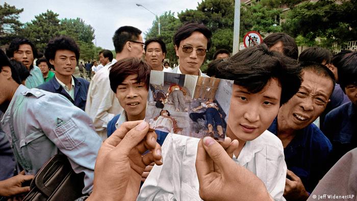 Люди держат фотографии погибших погибших родственников и друзей