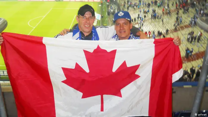 Victor mit seinem Bruder in der Veltins Arena. Stolz halten sie die kanadische Flagge hoch, doch heute sind sie Schalke Fans.