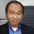 Francis Fukuyama in a professional photograph taken outside a building