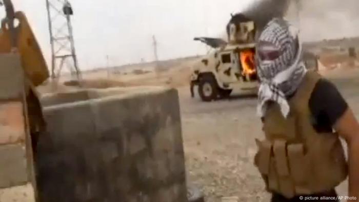 Offensive der ISIS Kämpfer am 12.06.2014. Ein Dschihadist steht vor einem brennenden Auto. Foto: Iraqi Revolution/AP Video