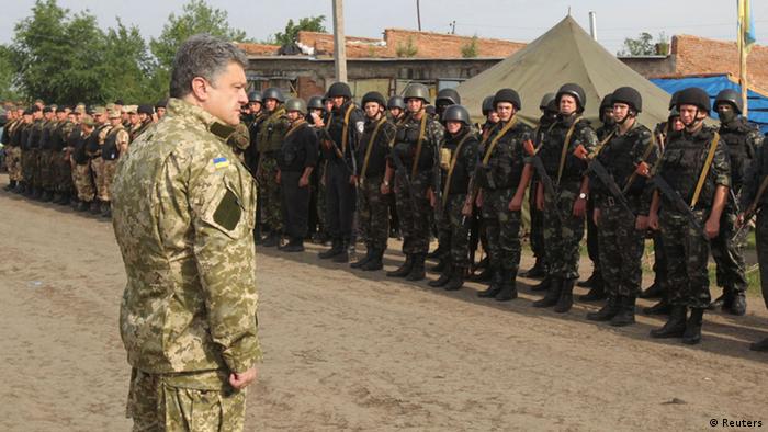 Poroshenko in military uniform in front of a detachment of soldiers