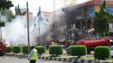 An emergency responder walks on a road near fire engines working to put a fire after a blast in the Wuse 2 neighbourhood of Abuja, June 25, 2014. At least 21 people were killed when a suspected bomb tore through the crowded shopping district in the Nigerian capital Abuja during rush hour on Wednesday, police said, adding to the toll of thousands killed in attacks this year. It was not immediately clear who was responsible for the blast and no one claimed responsibility. However, militant Islamist group Boko Haram has increasingly targeted civilians in its bloody five-year insurgency. REUTERS/Afolabi Sotunde (NIGERA - Tags: CIVIL UNREST CRIME LAW)