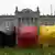 Drei Sparschweine in den Farben Schwarz, Rot und Gold stehen vor dem Reichstag in Berlin