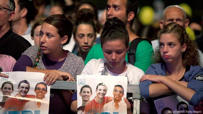 Young women hold the Pictures of tzhe three missing Teenagers (Foto: Lior Mizrahi/Getty Images)