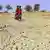 Indian women walking across dry desert land