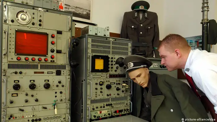 Ein Mann schaut in einem Museum auf eine alte Stasi-Abhöranlage, vor der eine Puppe eines Stasi-Offiziers steht (picture-alliance/dpa)