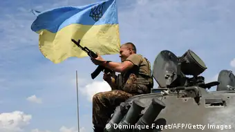 A tank with a man flying the Ukrainian flag (Photo: DOMINIQUE FAGET/AFP/Getty Images)