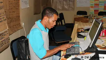 Journalist with headset in front of a computer