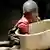 A young child reaching into a huge bowl for food