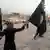 A member of "Islamic State" waves the group's black flag