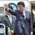 Japanese Prime Minister Shinzo Abe (C) and his wife Akie (R) wave as they depart for Mexico at Tokyo International Airport at Haneda on July 25, 2014.