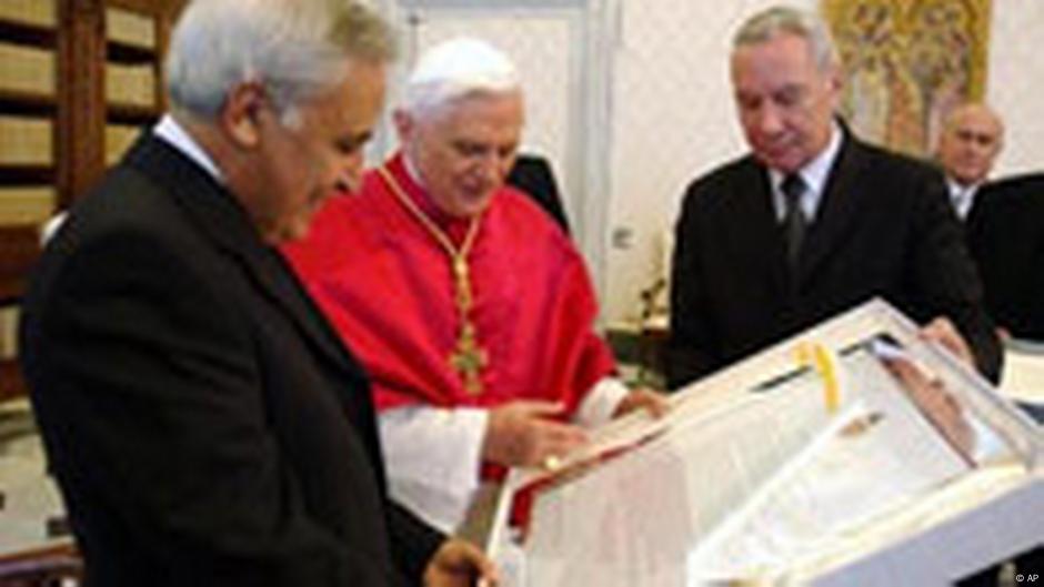 Predsednik Izraela Moše Kacav (levo) razmenjuje poklone sa papom Benediktom XVI u Vatikanu, 17. novembra 2005. Kacav je papi poklonio uokvirene fotografije nedavno otkrivenih mozaika za koje se veruje da potiču iz najstarije crkve u Svetoj zemlji. Benedikt je Kacavu poklonio uokviren i potpisan primerak „Nostra aetate“, koji je revolucionisao odnose Katoličke crkve sa Jevrejima.