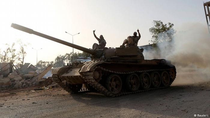 Fighters from the Benghazi Shura Council, which includes former rebels and militants from al Qaeda-linked Ansar al-Sharia, gesture on top of a tank next to the camp of the special forces in Benghazi July 30, 2014. On Wednesday, the eastern city of Benghazi was quieter after Islamist fighters and allied militia forces overran a special forces army base in the city in a major blow to a military campaign against Islamist militants there. The self-declared Benghazi Shura Council forces took over the base on Tuesday after fighting involving rockets and warplanes that killed at least 30 people. REUTERS/Stringer