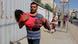 Man fleeing with child (Photo: AP Photo/Hatem Ali) Man fleeing with child (Photo: AP Photo/Hatem Ali)