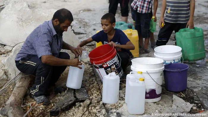 People in Gaza collect water in buckets
(Photo: MOHAMMED ABED/AFP/Getty Images)