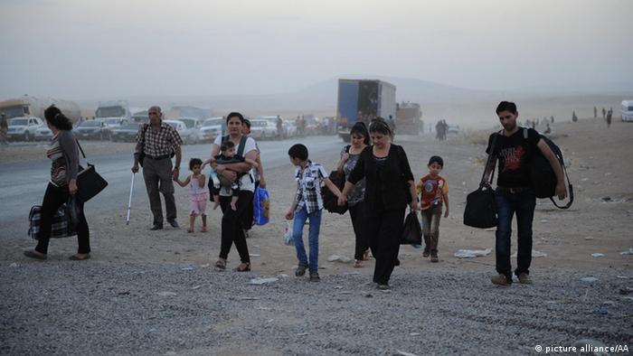 Thousands of Yazidi and Christian people flee Hamdaniyah town of Mosul to Erbil after the latest wave of ISIL advances that began on Sunday has seen a number of towns near Iraq's second largest city Mosul fall to the militants on August 6, 2014. (Mustafa Kerim - Anadolu Agency)