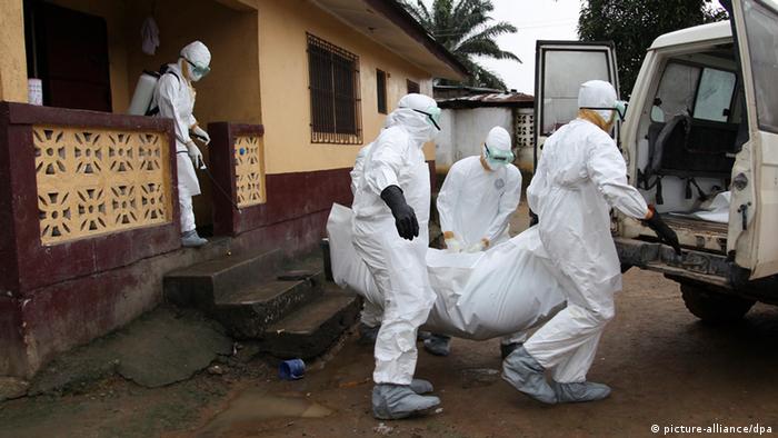 Nurses carry an Ebola victim's body out of a house in Liberia (Photo: EPA/AHMED JALLANZO)