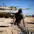 An Israeli reserve soldier checks a tank track near the border with Gaza. REUTERS/Amir Cohen (