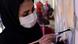 Graffiti-Künstlerin Shamsia Hassani malt mit einem Pinsel auf ein Wand Graffiti-Künstlerin Shamsia Hassani malt mit einem Pinsel auf ein Wand