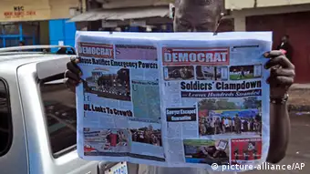 Liberia Westafrika Mann ließt Zeitung über Ebola