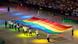 Die Athleten der Gay Games laufen ein und tragen eine große Flagge in Regenbogenfarben auf den Schultern. Die Athleten der Gay Games laufen ein und tragen eine große Flagge in Regenbogenfarben auf den Schultern.