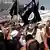 Menschen schwenken Fahnen der IS (Foto: AP)