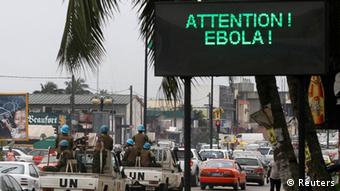 A UN convoy of soldiers passes a screen displaying a message on Ebola on a street in Abidjan, Ivory Coast (Photo: REUTERS/Luc Gnago)