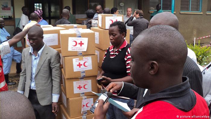 Ugandan helpers standing beside a medical delivery.