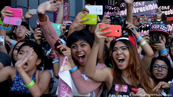 K-pop fans, mostly young girls, in South Korea, holding up their smartphones