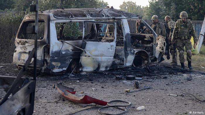 Ukrainian soldiers of the Donbass battalion near the burned-out bus