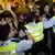 Polizeikräfte drängen eine demonstrierende Menschenmenge zurück