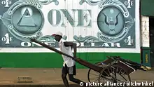 Homem leva carroça em frente a uma parede onde há uma nota de um dólar desenhada