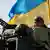 Украинский солдат на танке под национальным флагом