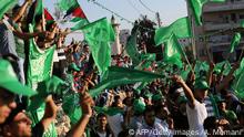 Palestinian supporters of the Islamist movement Hamas wave national and Hamas flags during a rally in the West Bank city of Ramallah on August 30, 2014. Last week, Hamas and Israel agreed an Egypt-mediated ceasefire to end a deadly 50-day war with Israel in Gaza that killed more than 2,100 Palestinians. AFP PHOTO / ABBAS MOMANI (Photo credit should read ABBAS MOMANI/AFP/Getty Images)
