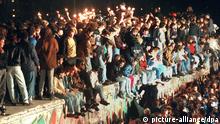 ARCHIV - Jubelnde Menschen sitzen mit Wunderkerzen auf der Berliner Mauer am 11.11.1989. Nach der Öffnung eines Teils der deutsch-deutschen Grenzübergänge in der Nacht vom 9. auf den 10. November 1989 reisten Millionen DDR-Bürger für einen kurzen Besuch in den Westen. In der Folge wurde die innerdeutsche Grenze abgebaut, seit dem 3. Oktober 1990 ist Deutschland wieder vereint. Foto: dpa (zu dpa-Themenpaket vom 06.11.) Wiederholung +++(c) dpa - Bildfunk+++