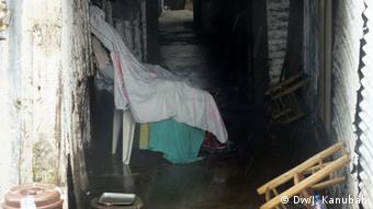 A draped body on a chair awaits collection