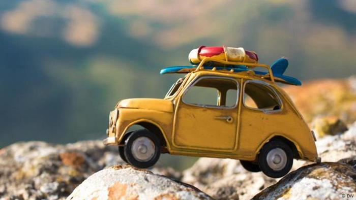  Ein gelbes Miniaturauto steht auf einem Felsen (DW)