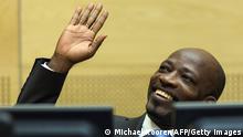 Ivorian ex-president's right-hand man Charles Ble Goude smiles and waves while at the courtroom of the International Criminal Court (ICC) for his initial appearance in The Hague, on March 27, 2014. Ble Goude faced International Criminal Court judges for the first time today for his alleged role in a deadly post-election standoff three years ago. The leader of the so-called Young Patriots, a fanatical group of Gbagbo supporters, is facing four counts of crimes against humanity for his role in the 2010-11 unrest which the UN said left 3,000 people dead. AFP PHOTO / POOL / MICHAEL KOOREN (Photo credit should read MICHAEL KOOREN/AFP/Getty Images)
