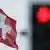 Eine Schweizer Flagge vor einer roten Ampel