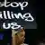Eine schwarze Frau hält ein Schild mit den Worten "Stopp killing us" in die Höhe (Foto: rtr)