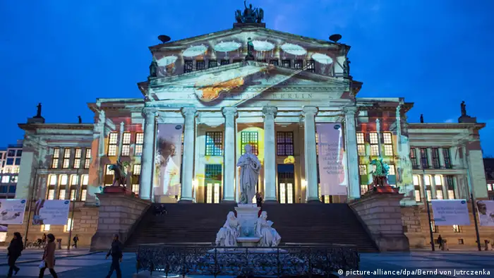 Eine Film-Projektion zeigt auf der Fassade des Schauspielhauses am Berliner Gendarmenmarkt die Geschichte des Hauses. Foto: Bernd von Jutrczenka/dpa 